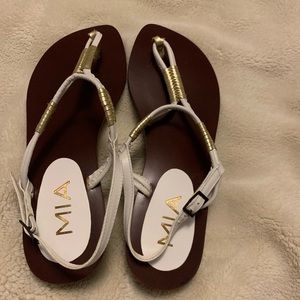 White leather sandals with golden accents